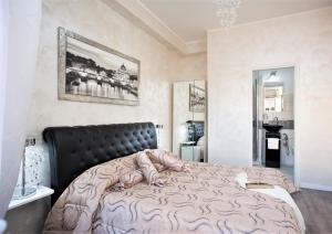 - une chambre avec un grand lit et une tête de lit noire dans l'établissement San Pietro Panoramic View, à Rome