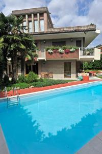 une grande piscine bleue en face d'une maison dans l'établissement The Flower Garden, à Scanzorosciate