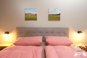 dwa łóżka w sypialni z trzema obrazami na ścianie w obiekcie AlexaFerien w mieście Bad Tölz