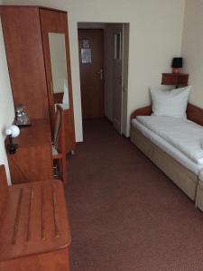 a hotel room with a bed and a desk and a mirror at Hotel Żagiel in Niewiesze