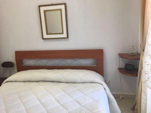 Schlafzimmer mit einem Bett und einem Spiegel an der Wand in der Unterkunft Cordovena in Capo dʼOrlando