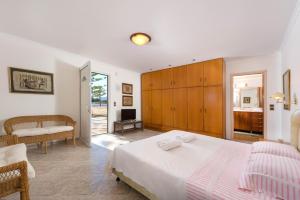a bedroom with a bed and a living room at Villa Maria Beachfront Residence in Kiotari
