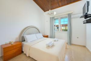 a bedroom with a bed with two towels on it at Villa Maria Beachfront Residence in Kiotari