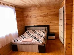 バイカリスクにあるGuest house Nephritisのログキャビン内の小さなベッドルーム1室(ベッド1台付)