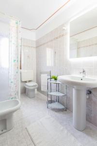 een witte badkamer met een wastafel en een toilet bij Eden Rock in Cannobio