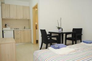 a room with two beds and a table and a kitchen at Pavlic Apartments in Betina