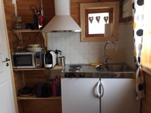 eine kleine Küche mit einer Spüle und einer Mikrowelle in der Unterkunft Lammsjon Relax in Sille