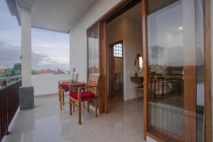a dining room with a table and chairs and a balcony at Budi House Bungalows in Ubud