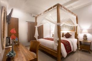 a bedroom with a bed with a canopy at Budi House Bungalows in Ubud +46 photos
