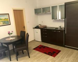 a kitchen and dining room with a table and a sink at Apartmani Matosevic in Ivankovo