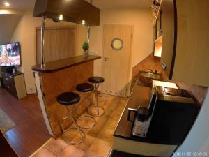a kitchen with two bar stools and a counter at Apartament Koja in Mrągowo