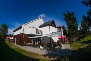 a building with tables and chairs in front of it at Trafo Base Camp in Kroczyce