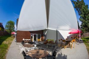 eine Terrasse mit Tischen, Stühlen und Sonnenschirmen in der Unterkunft Trafo Base Camp in Kroczyce