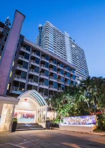 Un gran edificio con palmeras delante. en Sandalay Resort, en Pattaya central