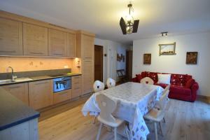 a kitchen and dining room with a table and chairs at Vajolet in Campitello di Fassa +4 photos
