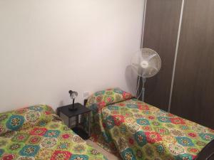 1 dormitorio con 2 camas y ventilador en Altas Mareas en Las Grutas