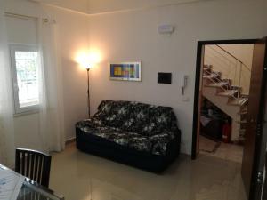 a living room with a couch and a staircase at La Casa del Professore in Santa Teresa di Riva
