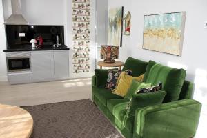 a living room with a green couch and a table at Principia Suites in León