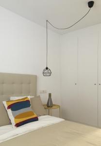 ein Schlafzimmer mit einem Bett und einer Hängeleuchte in der Unterkunft Apartment Santa Teresa in Altea