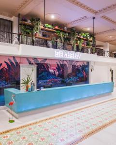 a lobby with a blue counter with plants on the wall at Sandalay Resort in Pattaya