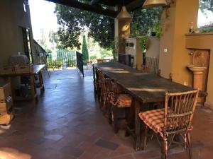 a large wooden table and chairs in a patio at Villetta Gabriella in Impruneta