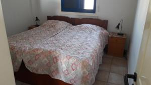 a bedroom with a bed with a quilt on it at Rita SeaView Apartment in Perivolia
