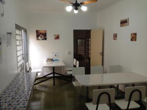 a living room with a table and chairs and a ceiling at Hostel Araucaria in Ribeirão Preto