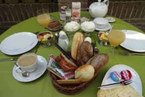 een tafel met een broodmand en kopjes koffie bij Bed & Breakfast VanAgt in Vlijmen