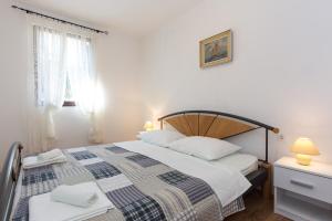sypialnia z dużym łóżkiem i oknem w obiekcie Apartments Karen w Krku
