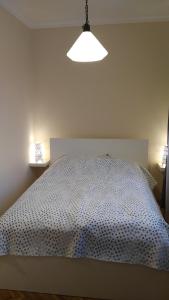 a white bed in a room with two lamps at Heidi Apartman in Szeged