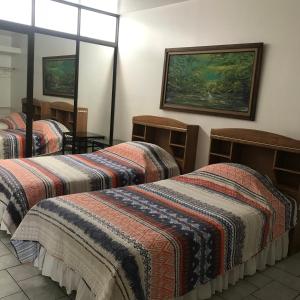 a hotel room with three beds and a window at Oro Apart Hotel in San Antonio