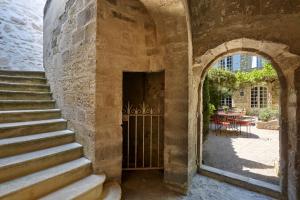 une entrée avec une arche et des escaliers dans l'établissement Hotel De L'Atelier, à Villeneuve-lès-Avignon