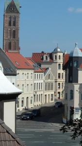 a group of buildings with a clock tower and a church at Apartment unterm Dach in Wismar
