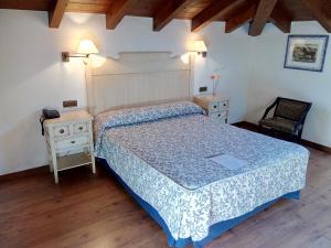 1 dormitorio con 1 cama, 2 mesas y 1 silla en Hotel Aldama Golf, en Quintana de Llanes