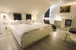 biała sypialnia z łóżkiem i krzesłem w obiekcie SOLEWERK Hotel w mieście Bad Salzungen