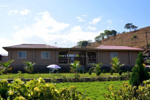 une maison avec une pelouse devant dans l'établissement Kunjwan Resort, à Bhor