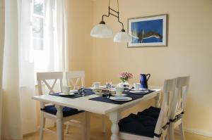 フーズムにあるFriesenhaus Winnie-Poohのダイニングルームテーブル(椅子付)、白いテーブル(青いテーブルクロス付)