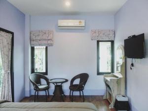 a bedroom with two chairs and a table and a bed at Big House Resort in Trat