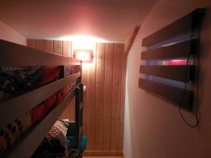 a bedroom with a bunk bed and a light on the wall at Gîte Toukoul in Autrans