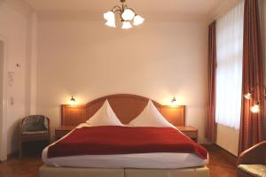 Pension Villa Beer في شترالزوند: غرفة نوم بسرير ومخدات حمراء وبيضاء