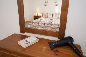 a mirror on top of a wooden table in front of a bed at Summer Dream in Vlachata