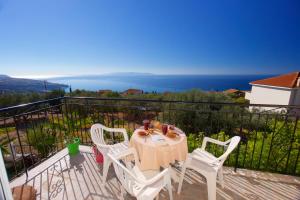 einen Tisch und Stühle auf einem Balkon mit Meerblick in der Unterkunft Summer Dream in Vlachata