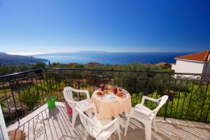 a table and chairs on a balcony with a view of the ocean at Summer Dream in Vlachata