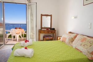 a bedroom with a green bed with towels on it at Summer Dream in Vlachata