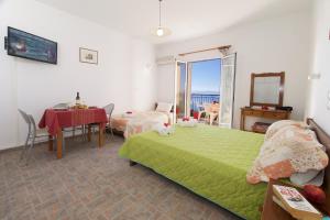 a bedroom with a green bed and a table and a window at Summer Dream in Vlachata