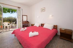 a bedroom with a red bed with two towels on it at Summer Dream in Vlachata