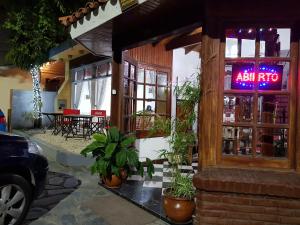 un restaurante con un cartel de neón en la ventana en Hotel El Cisne, en Villa Gesell
