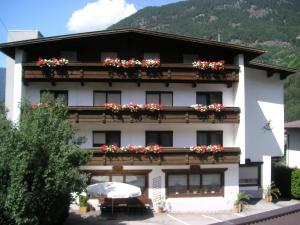 ein weißes Gebäude mit Blumenkästen an den Fenstern in der Unterkunft Pension Garni Ötztalerhof in Sautens