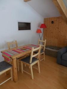 a dining room with a table and chairs and a couch at Gîte Toukoul in Autrans