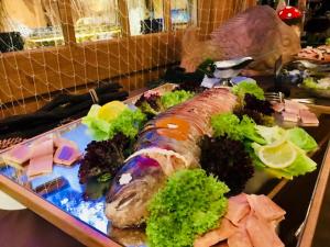 uma bandeja com um peixe e vegetais numa mesa em Hotel Haus Wiesengrund em Hallenberg